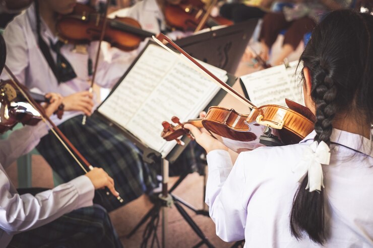 Studentinnen spielen Violine in der Gruppe.
