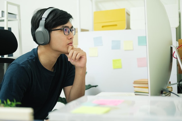 Studie des jungen Mannes vor dem Laptop-Computer zu Hause