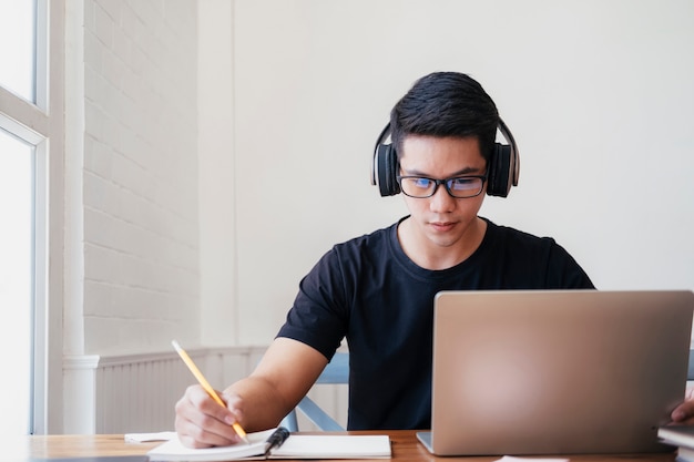 Studie des jungen mannes zu hause unter verwendung des laptops und online lernen