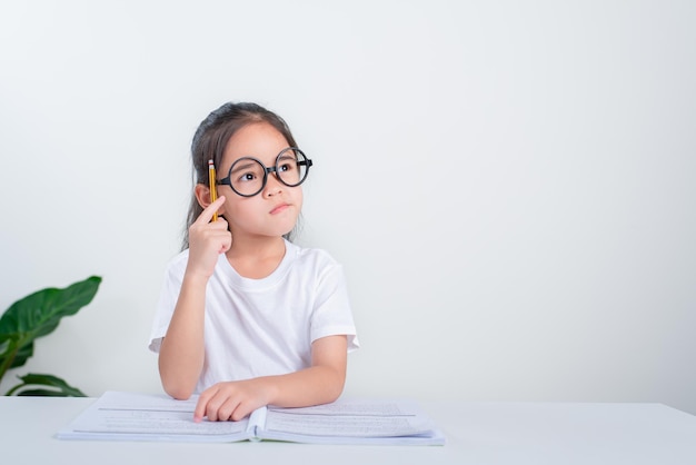 Studie für kleine Mädchen, die Tests in der Grundschule durchführen Kinder, die Notizen im Klassenzimmerkonzept schreiben