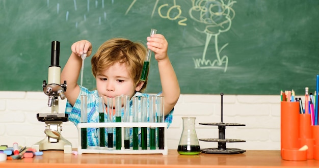 Studienbeihilfe und Stipendium Junge beim Chemietest Wunderkind und Frühförderung Kleiner Schüler lernt Chemieschule Chemielabor Praktisches Wissenskonzept Flüssigkeiten entdecken