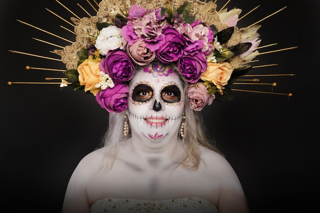 Studio-Porträt einer Frau mit Catrina-Makeup und Hochzeitskleidung mit Zuckerkopf-Make-up