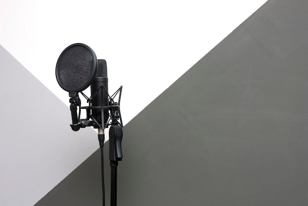 Studio schwarzes Mikrofon gegen graue Wand Nahaufnahme