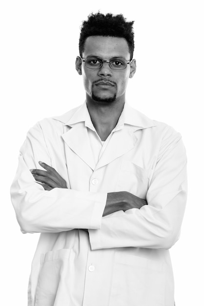 Studioaufnahme des jungen gutaussehenden bärtigen afrikanischen Mannarztes lokalisiert gegen weißen Hintergrund in Schwarzweiss