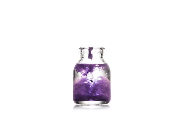 Studioaufnahme eines Glasgefäßes mit violetter Flüssigkeit isoliert auf weiß