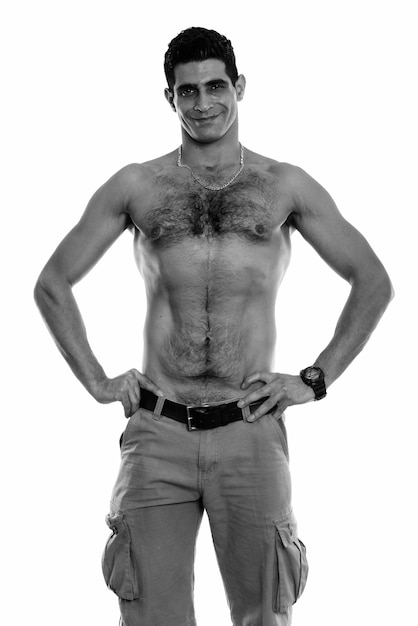 Foto studioaufnahme eines jungen muskulösen persischen mannes mit nacktem oberkörper isoliert vor weißem hintergrund in schwarz und weiß