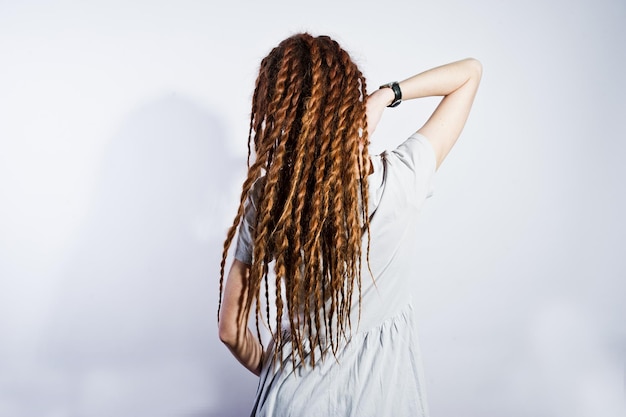 Studioaufnahme eines Mädchens im grauen Kleid mit Dreads auf weißem Hintergrund