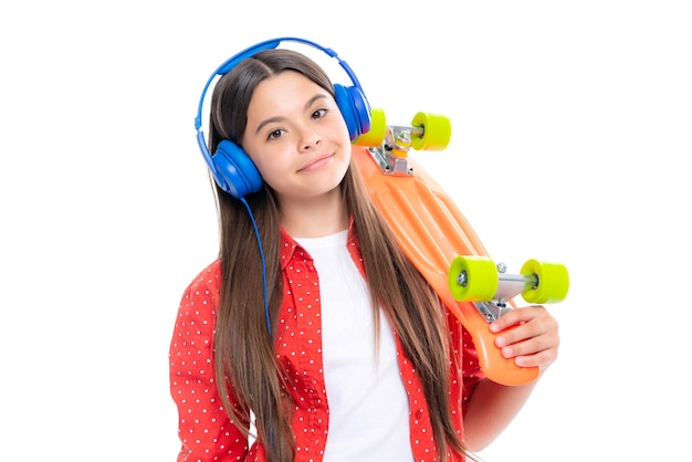 Studioaufnahme eines trendigen Teenager-Modemodells im lässigen Look Teenager-Jugend-Hipster-urbaner Lebensstil Kindermädchen im Streetstyle in Hipster-Kleidung mit einer Skateboard-Wasserflasche und Kopfhörern