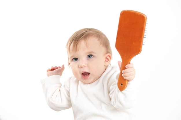 Studiofoto mit weißem Hintergrund eines Babys mit einem Kamm in der Hand