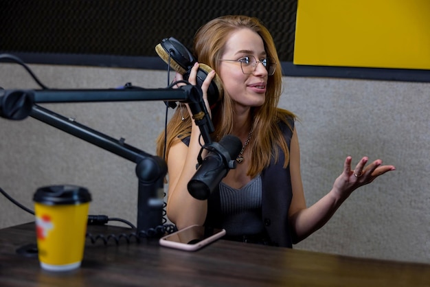 Studiogast. Ingwer lächelnde junge Frau im Radiostudio