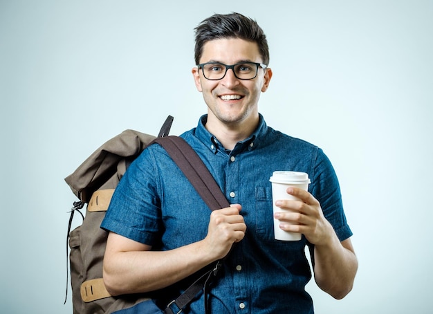 Studioporträt des schönen jungen Mannes mit Rucksack