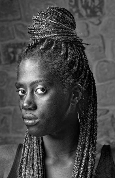 Studioporträt einer jungen schwarzen Frau mit Zöpfen