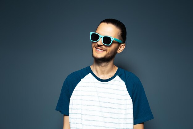 Studioporträt eines jungen gutaussehenden lächelnden Mannes mit Sonnenbrille