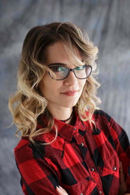 Studioporträt eines Mädchens mit Brille auf grauem Hintergrund