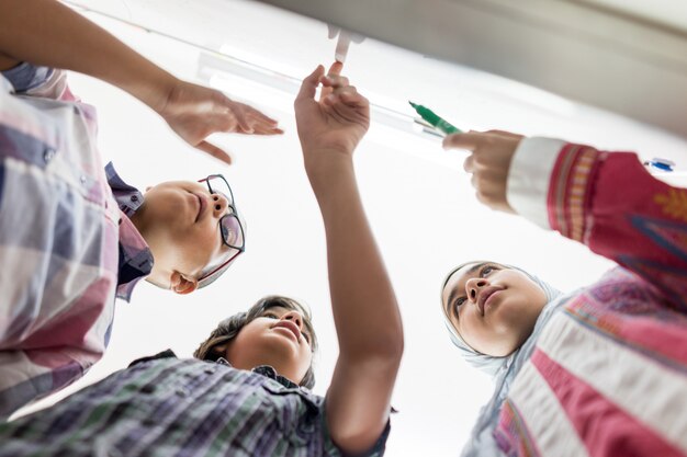 Studnets discutiendo una pregunta de matemáticas sobre whitebpard en el aula