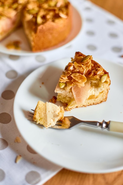 Stück Apfel- oder Birnentörtchen mit Karamellnüssen auf Draufsicht des Holztischkopierraums