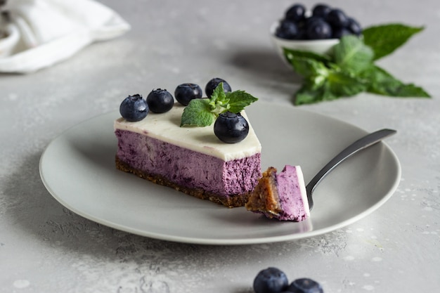 Stück Blaubeerkäsekuchen, frische Blaubeeren und Minze.