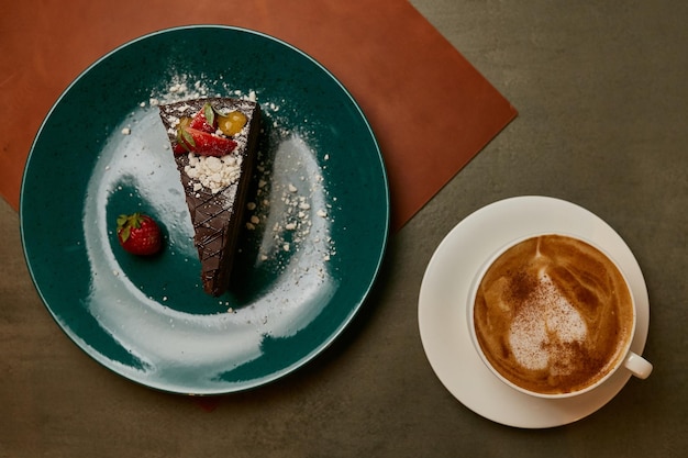 Stück Brownie-Kuchen auf einem grünen Teller Stück Kuchen auf einem Teller mit Kaffee