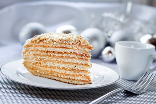 Stück der Torte auf einer Platte mit Weihnachtsbällen