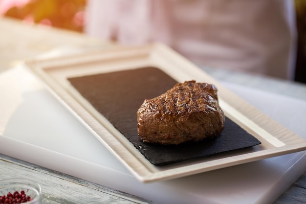 Stück Fleisch auf Teller. Steak von brauner Farbe. Saftiger Kalbsbraten. Einfaches und appetitliches Gericht.