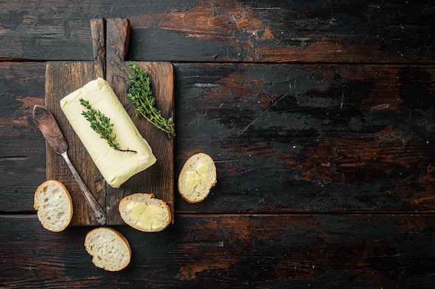 Stück frische Butter auf altem dunklem Holztisch