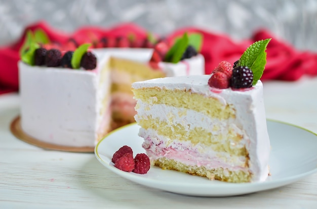 Stück frischer Keksjoghurt weißer Joghurtkuchen mit frischen Himbeeren und Brombeeren