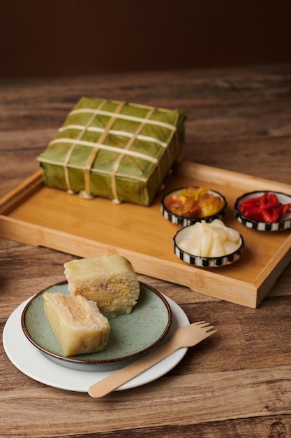 Stück für klebrigen Reiskuchen, der für die Tet-Feier neben einem Tablett mit eingelegtem Gemüse zubereitet wird