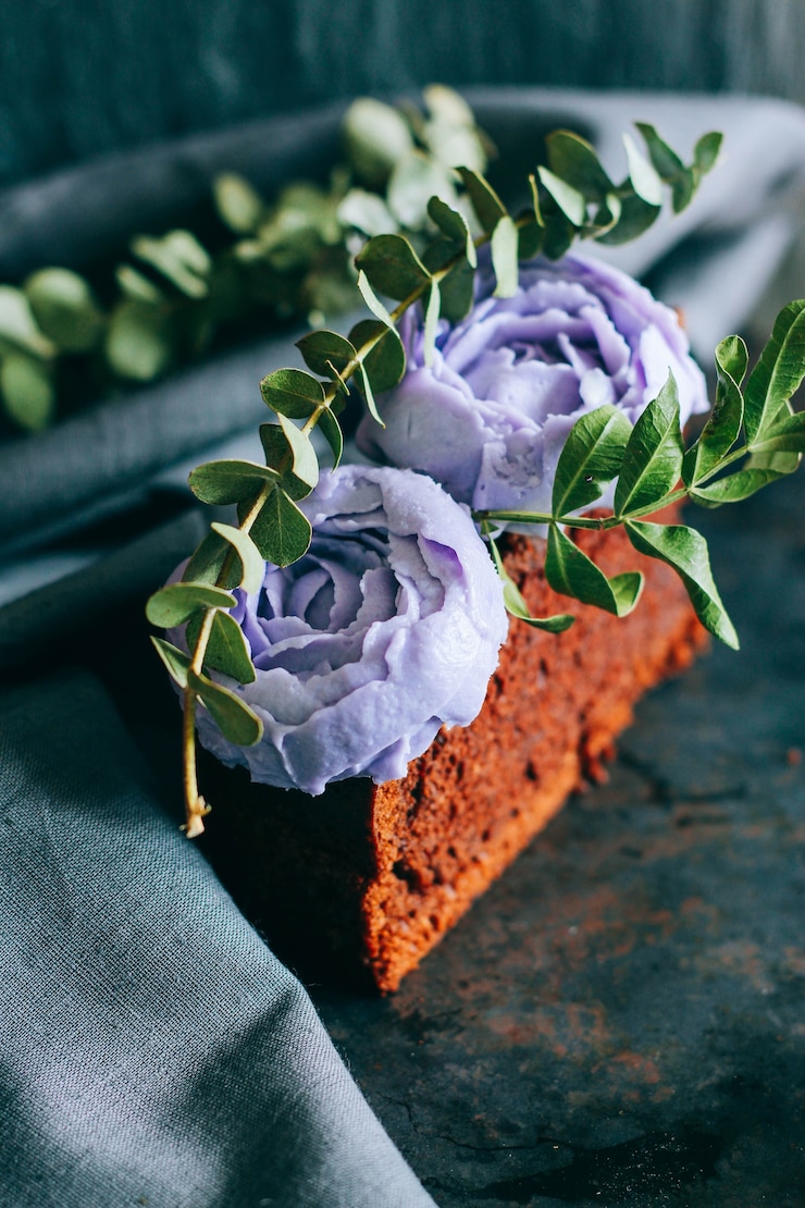 Foto stück geburtstagschokoladenkuchen mit purpurroten sahnerosen