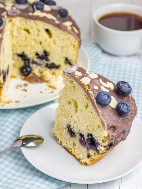 Stück hausgemachten Blaubeerkuchen mit Zuckerguss und Beeren oben drauf