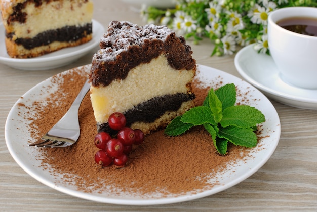 Stück Käsekuchenkuchen mit Mohnschicht zum Kaffee