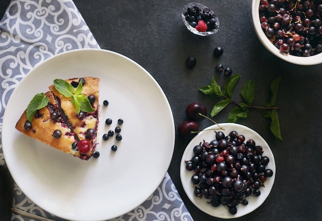 Stück Kuchen mit Blaubeeren, Himbeeren und Minze zum Nachtisch