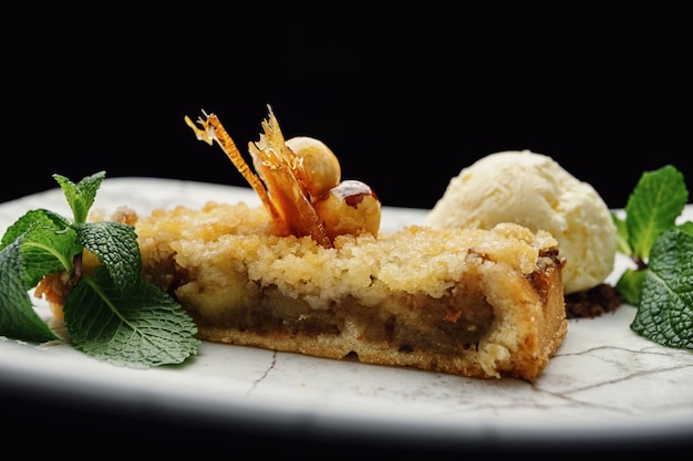 Stück Kuchen mit Äpfeln und Eis