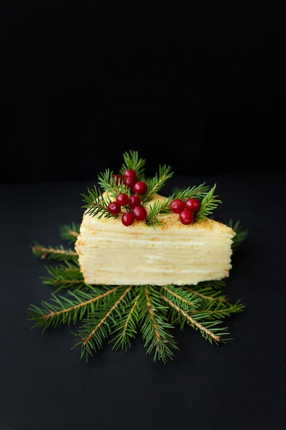 Stück Kuchen mit Zweigen und Beeren dekoriert