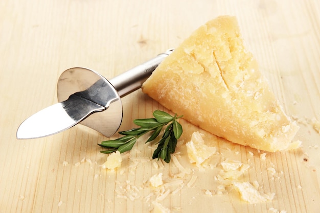 Foto stück parmesan-käse mit messer auf holztisch nahaufnahme