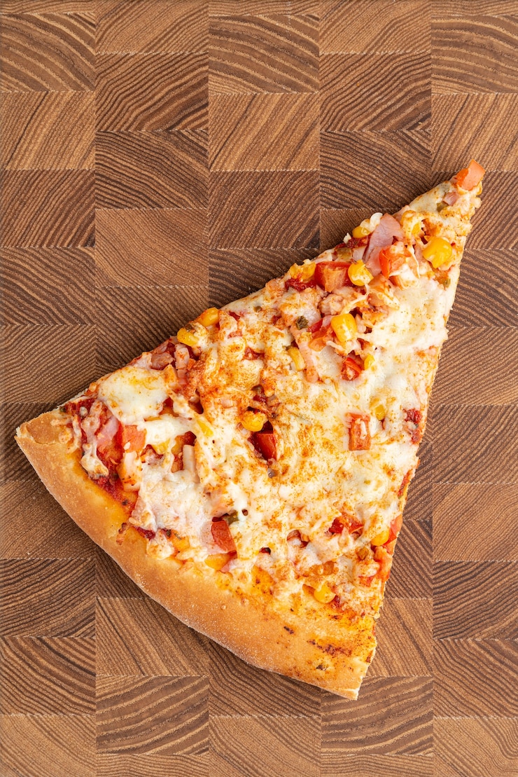 Foto stück pizza auf draufsicht des hölzernen hintergrundes