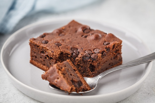 Stück Schokolade Vegan-Kuchen mit Schokoladenplätzchen und Nüssen.