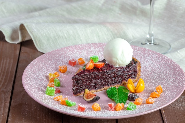 Stück Schokoladen-Mandel-Maismehl-Kuchen mit Balsamico-Nieselregen und Eis