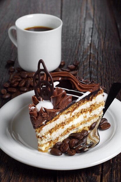 Stück Schokoladenkuchen und Tasse Kaffee auf dunklem Holztisch