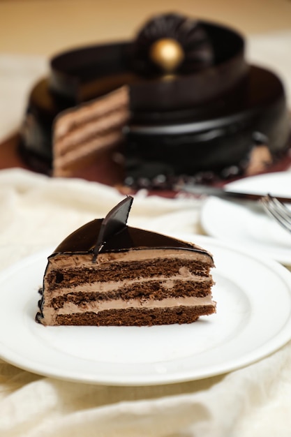 Stück Schwarzwälder Kirschtorte mit Schokoladenstückchen, Gabelzucker, gebacken, serviert auf einem Teller, isoliert auf dem Tisch, Seitenansicht, Backcafé