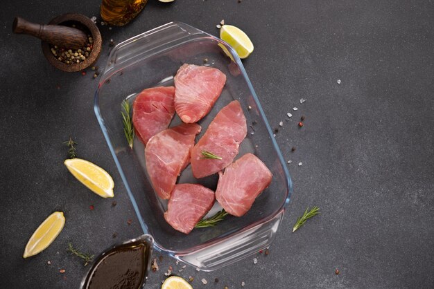 Stücke frisches Thunfischfilet in einer Küchenschüssel aus Glas und Sojasauce-Marinade in einer Soße