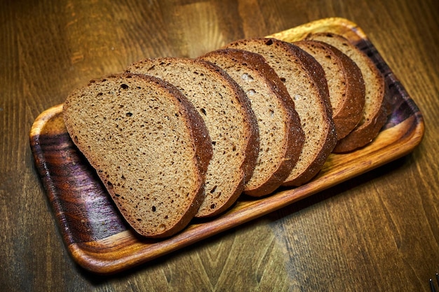 Stücke Graubrot liegen auf Holztablett