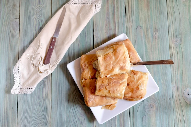 Stücke hausgemachter Kuchen mit Hühnergemüse und Käse auf einem Holztisch in der Nähe