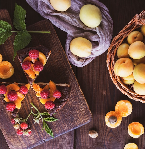 Stücke Käsekuchen mit Aprikose und Himbeere