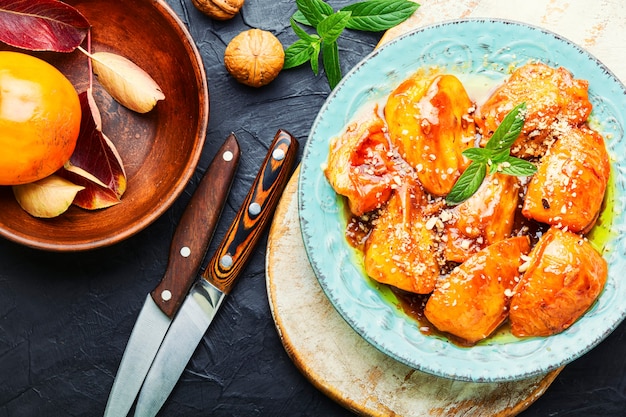 Stücke karamellisierte Kaki. Herbstliche Dessertsüße, karamellisierte Kaki.