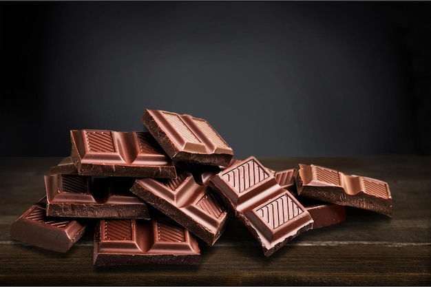 Stücke köstlicher Schokolade auf Hintergrund isoliert