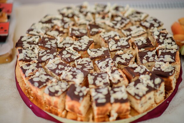 Stücke Schokoladenkuchen mit weißer Creme auf rundem Teller