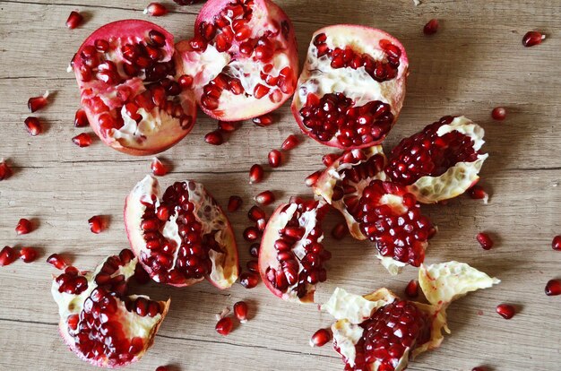 Stücke und Samen reifer Granatapfel auf einem Holztisch. Frische Granatäpfel auf einem Holztisch, selektiver Fokus