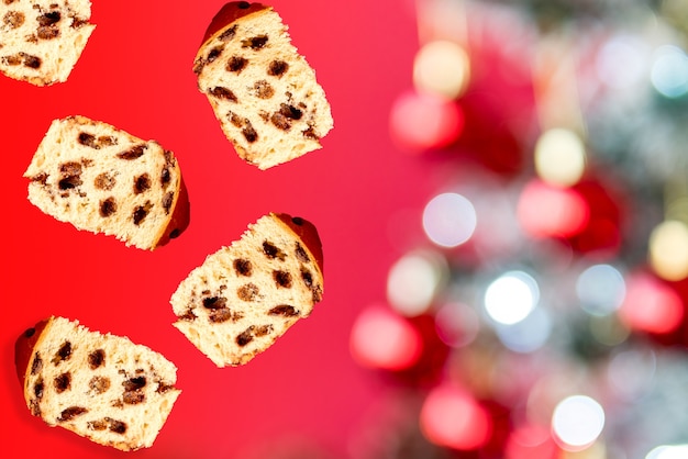 Stücke von Schokoladenpanettone. Chocottone, der auf Weihnachtshintergrund in Bewegung fällt.