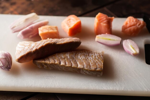 Stücke von weißem und rotem Fisch auf einem Schneidebrett Vorbereitung zum Kochen