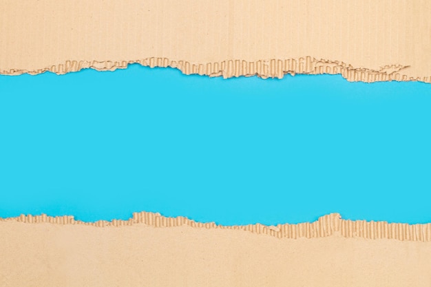 Stücke zerrissener Pappe auf blauem Hintergrund mit Kopierraum